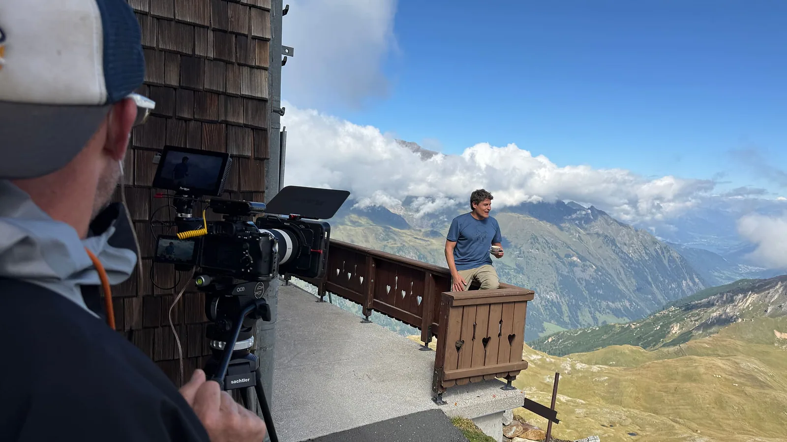Presentator voor de camera op een terras hoog in de bergen